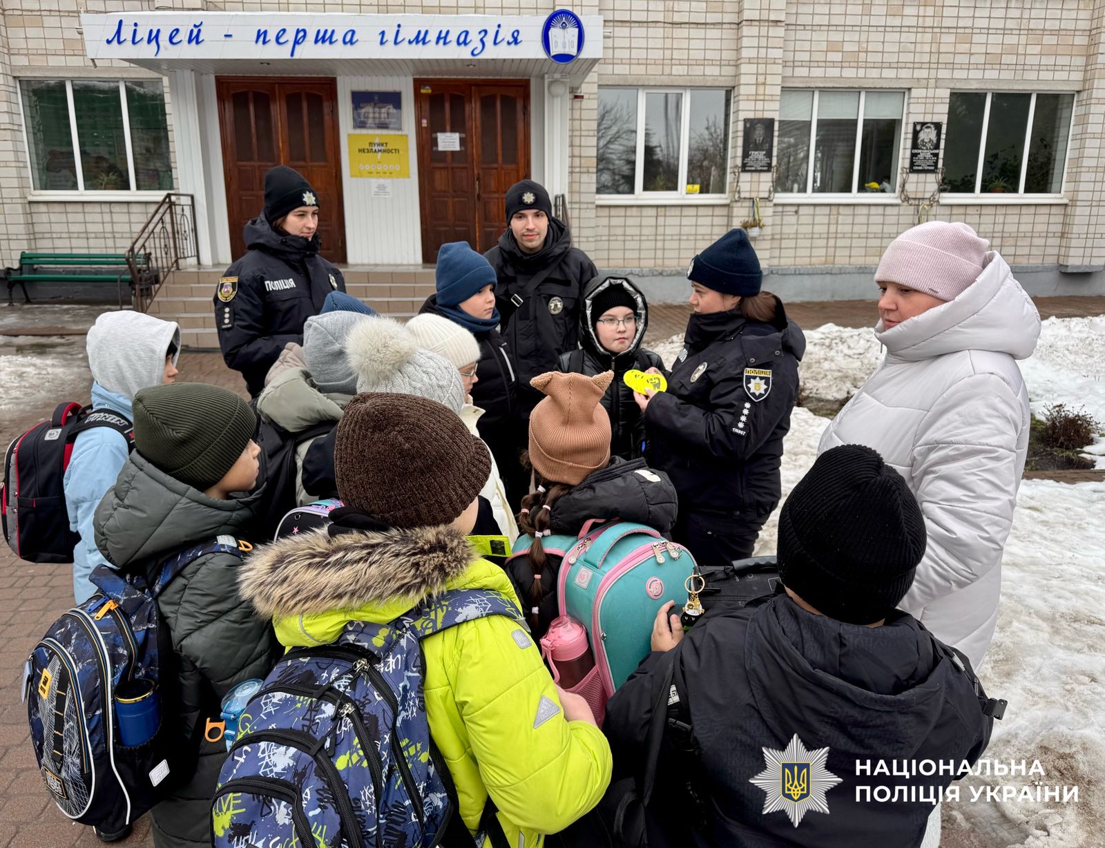 На фотографії зображені діти із світлоповертальними флікерами, які роздали поліцейські київщини, аби вони були помітними у темряві.