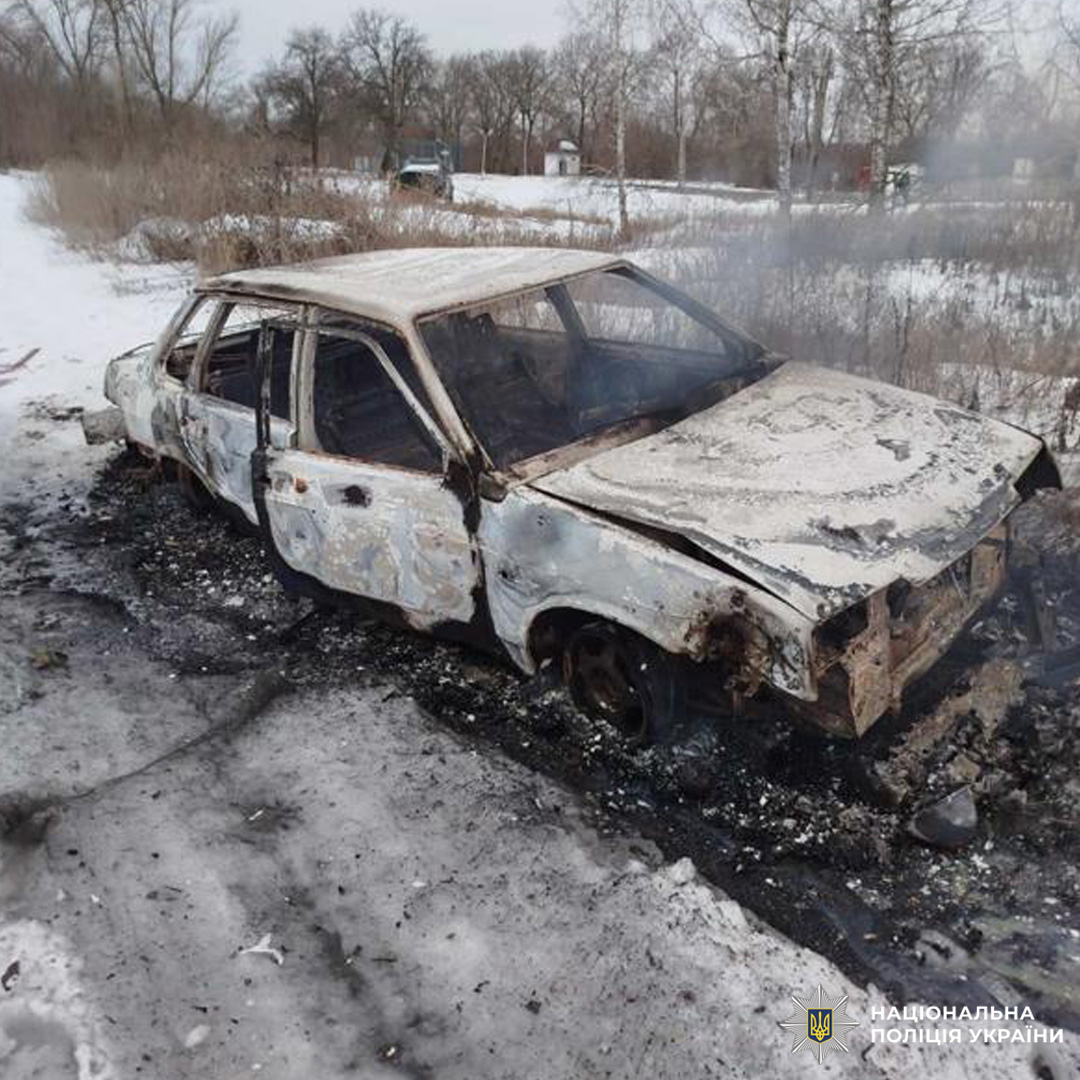 Повністю знищений вогнем автомобіль стоїть на засніженому узбіччі, навколо видно сліди пожежі.