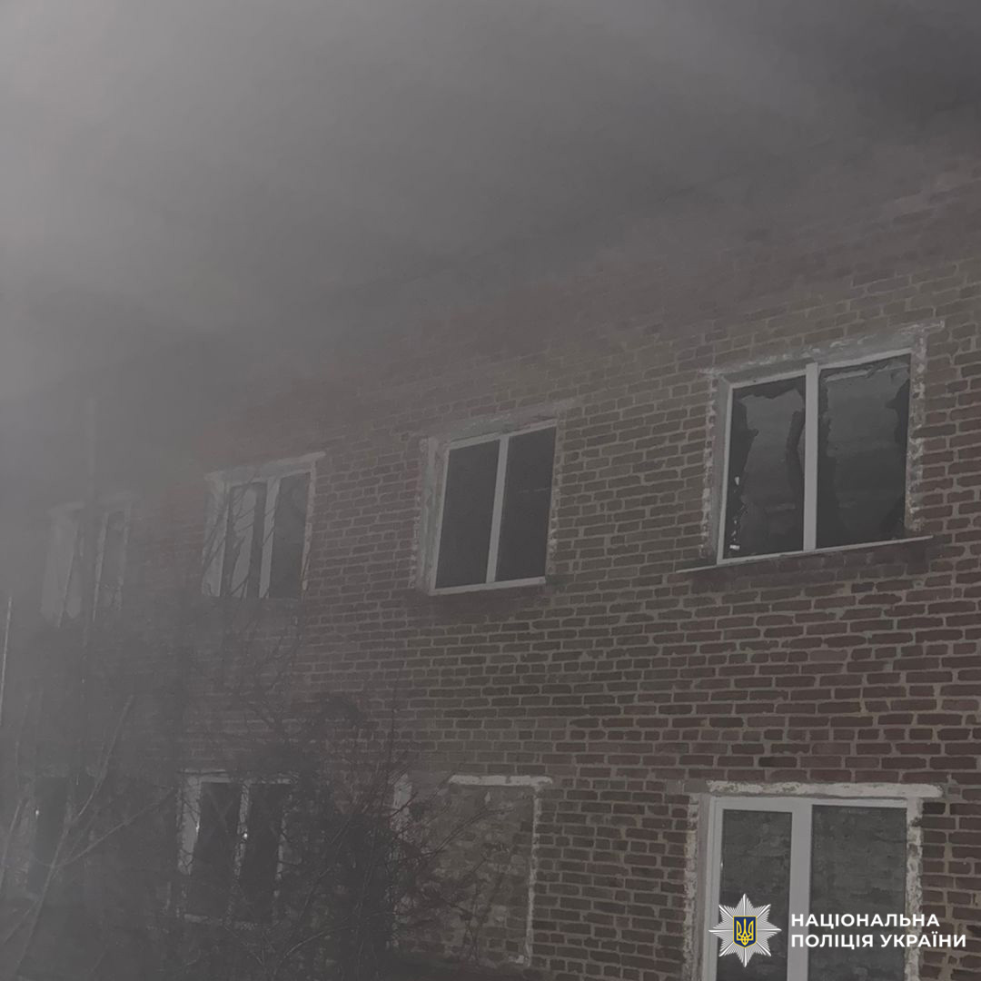 Двоповерховий будинок із розбитими вікнами, верхню частину будівлі огортає густий дим.