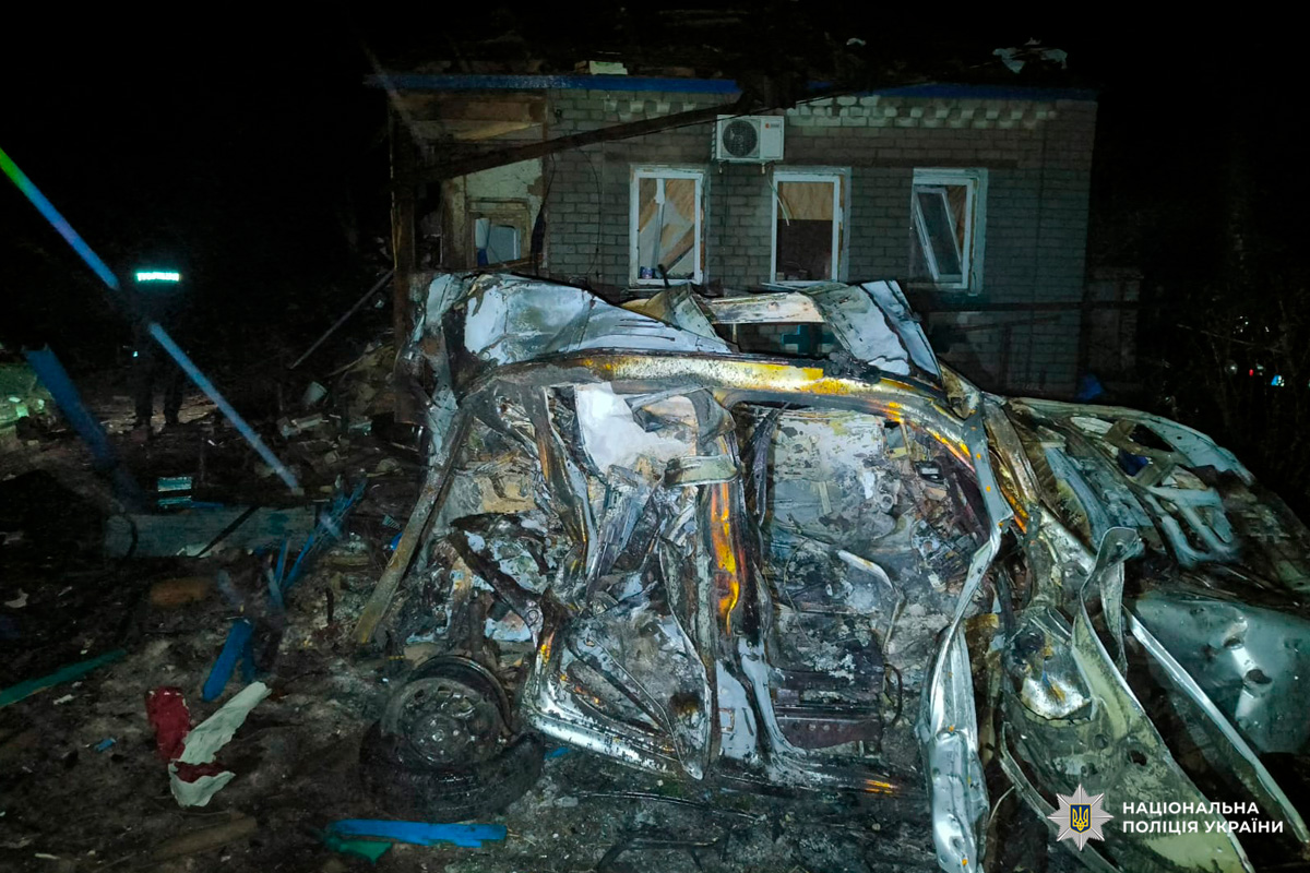 Автомобіль повністю знищений, будівля має видимі пошкодження - вибиті вікна та руйнування стін.