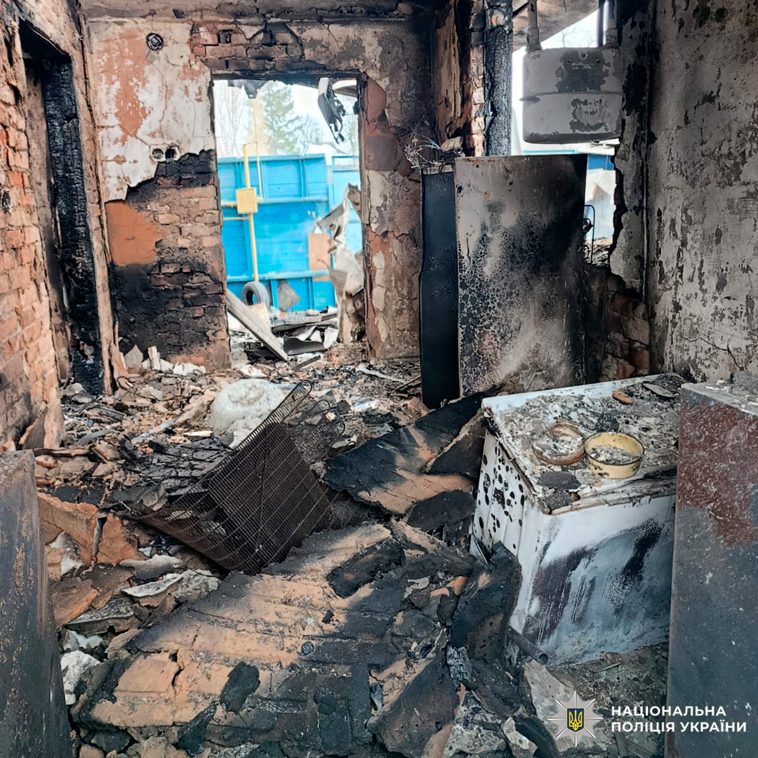 Всередині зруйнованої будівлі видно наслідки пожежі - обгорілі стіни, уламки деревини та металу, пошкоджена побутова техніка.