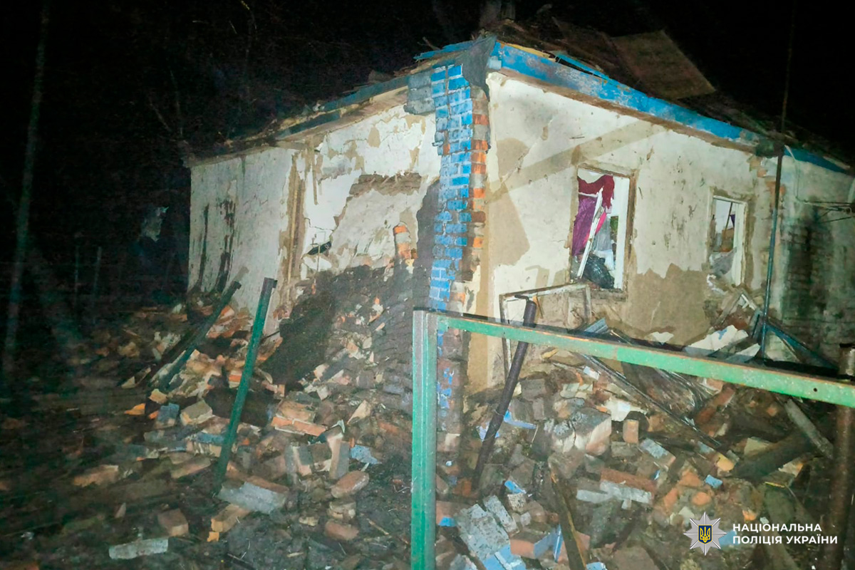 Будівля з серйозними пошкодженнями після руйнівної події - тріщини у стінах, уламки та обвалений дах.