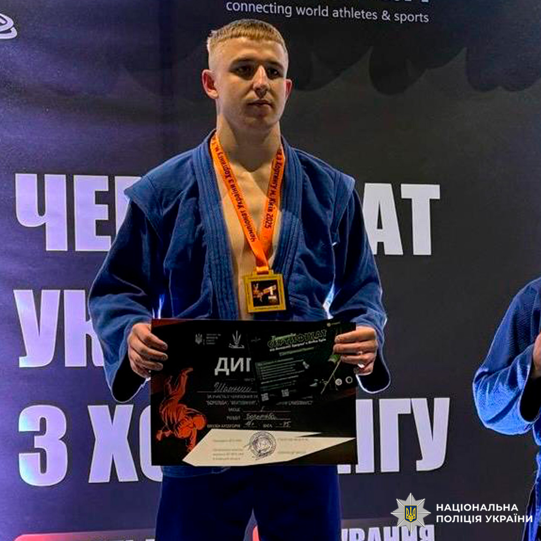 Спортсмен у синьому кімоно з медаллю та дипломом на п’єдесталі.