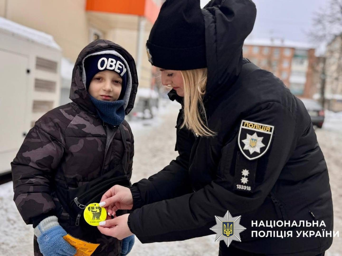 На фото зображена поліцейська під час спілкування з дитиною