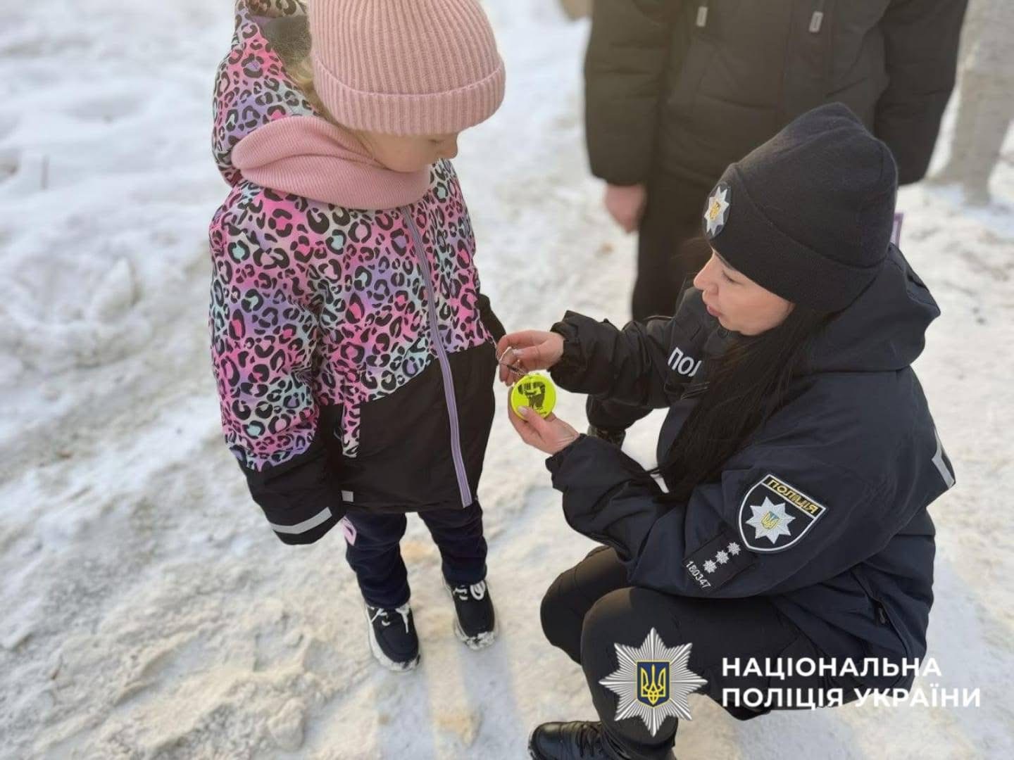 На фото зображена поліцейська яка спілкується із дитиною