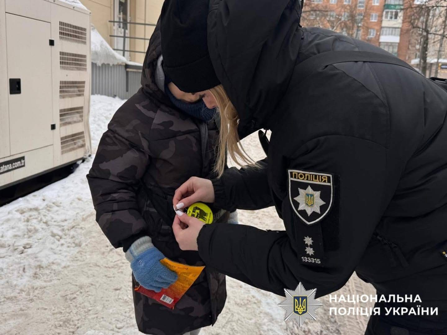 На фото зображена поліцейська превенції під час спілкування з дитиною