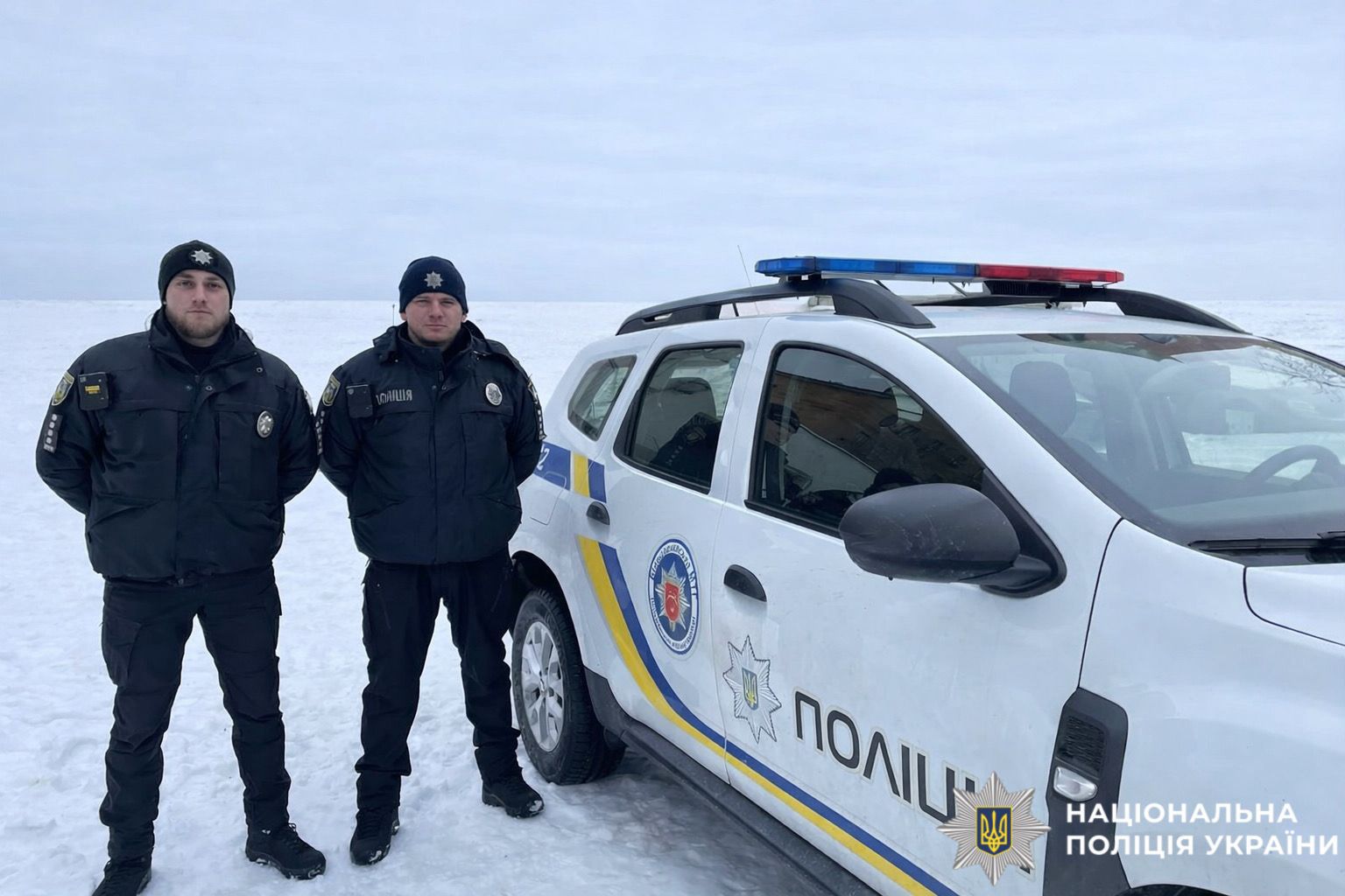 На фотографії зображені поліцейські офіцери громади Київщини, яким вдалося своєчасно врятувати життя водійки.