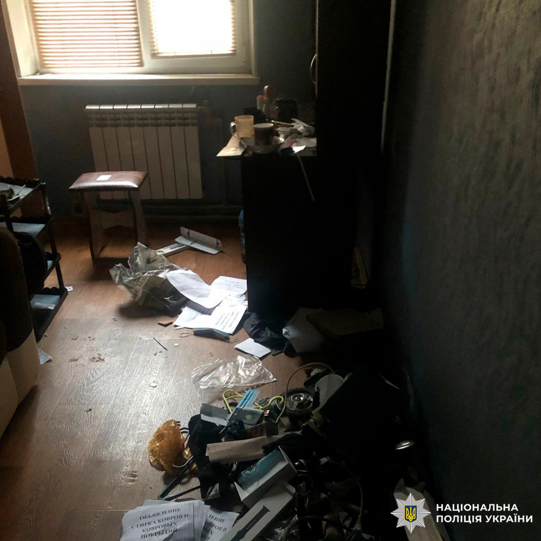 Сліди хаосу: кімната з розкиданими речами, приглушеним світлом і табуретом біля вікна.