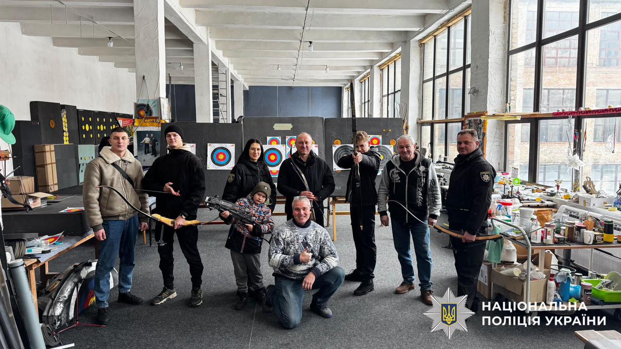 На фотографії зображено правоохоронців, які спільно з ветеранами відвідали столичний тир, де випробували свої сили у стрільбі з лука.