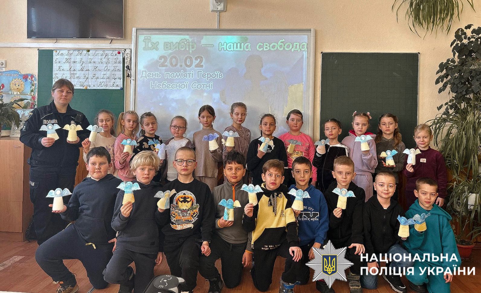 На фотографії зображені діти та поліцейська, які спільно до дня Героїв Небесної Сотні виготовляли паперових ангелів.