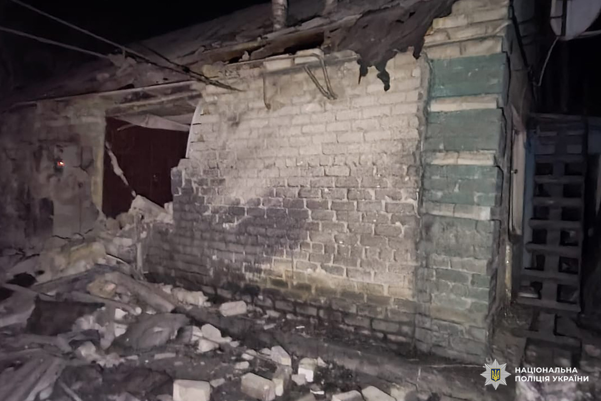 Цегляна будівля після руйнування: пошкоджені стіни, уламки на землі, частково зруйнований дах.