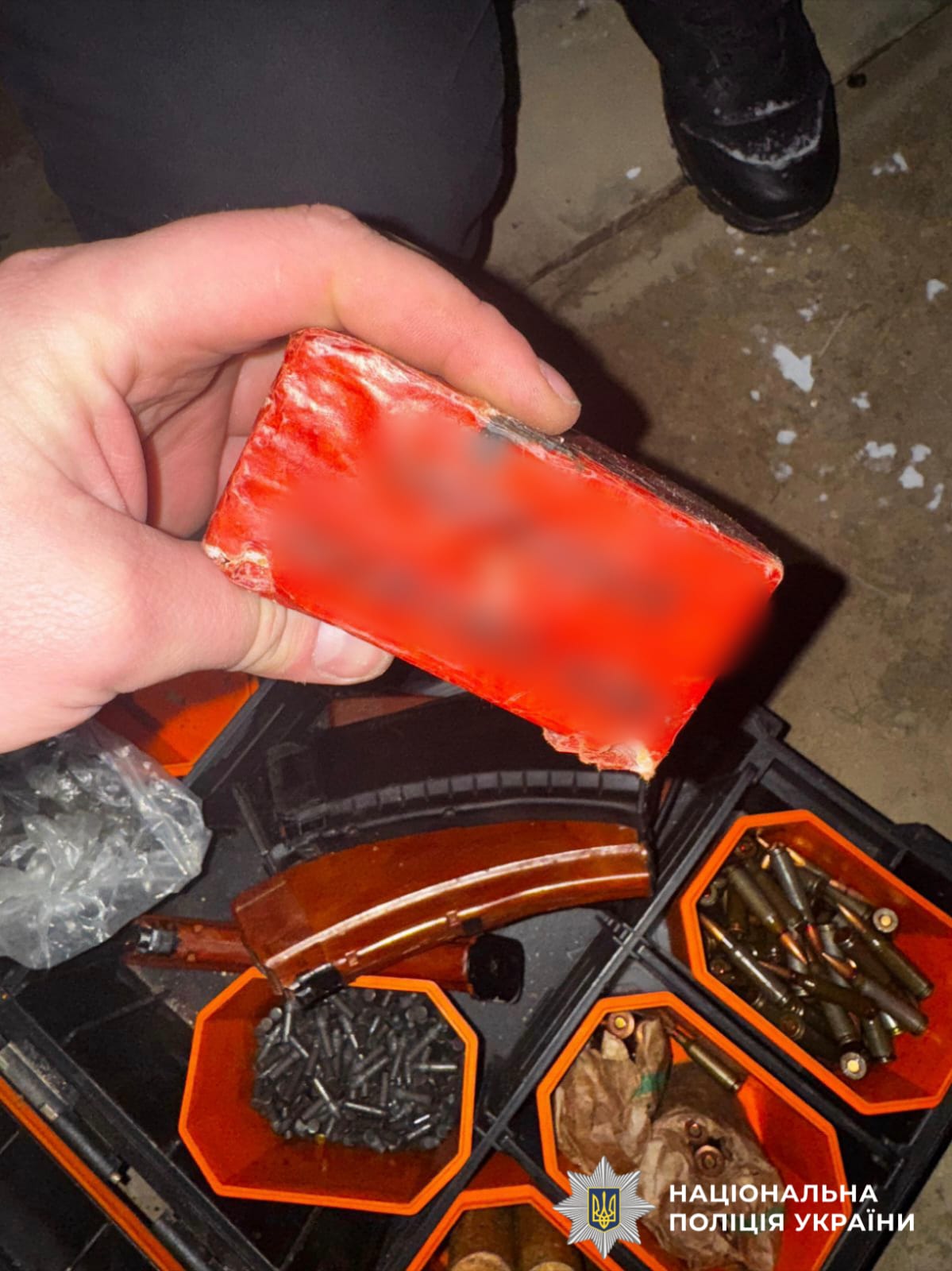 На фотографії зображено виявлені та вилучені речові докази, серед яких боєприпаси та вибухові речовини.