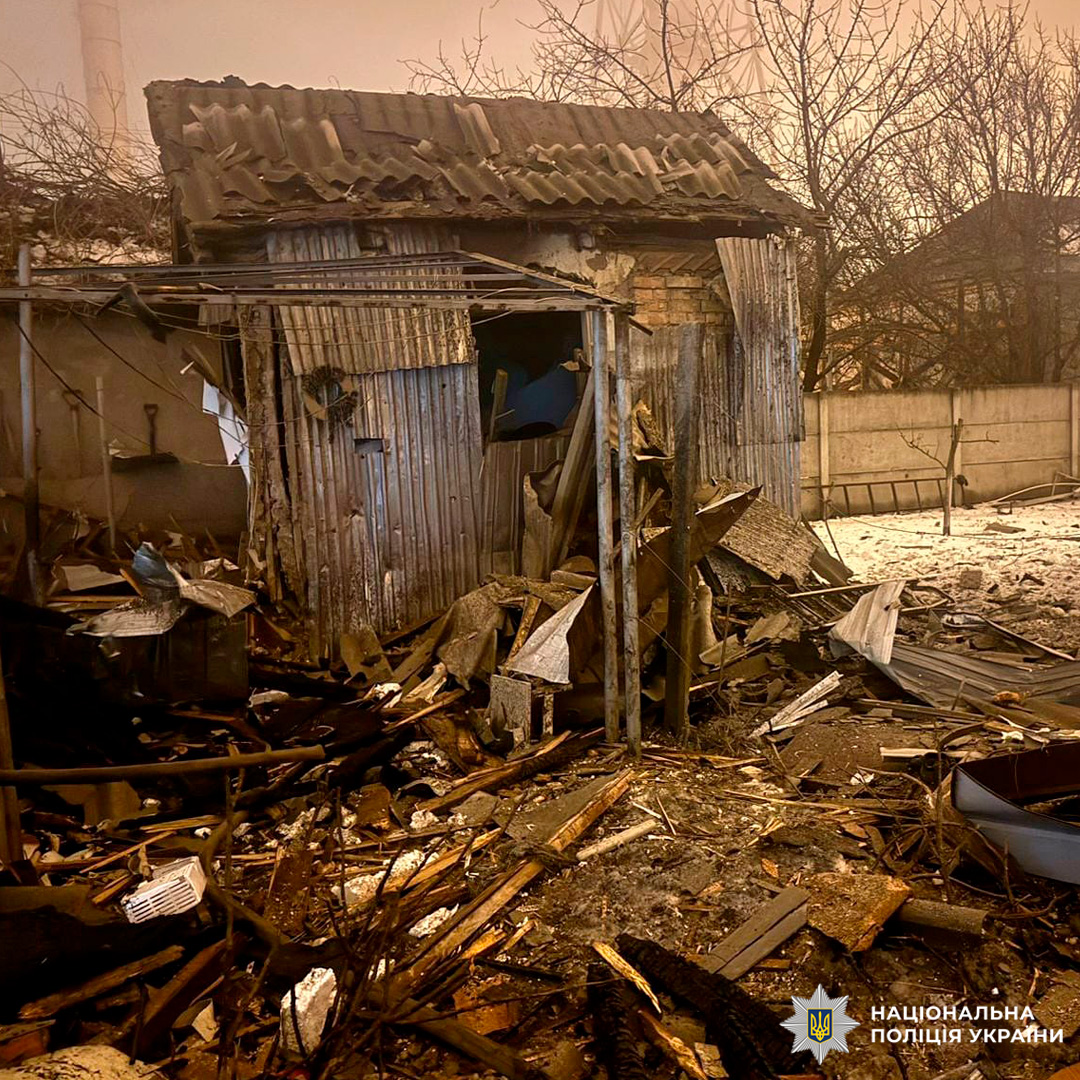 Зруйнована невелика будівля з металевими та цегляними стінами, дах частково обвалений, навколо уламки та сніг.