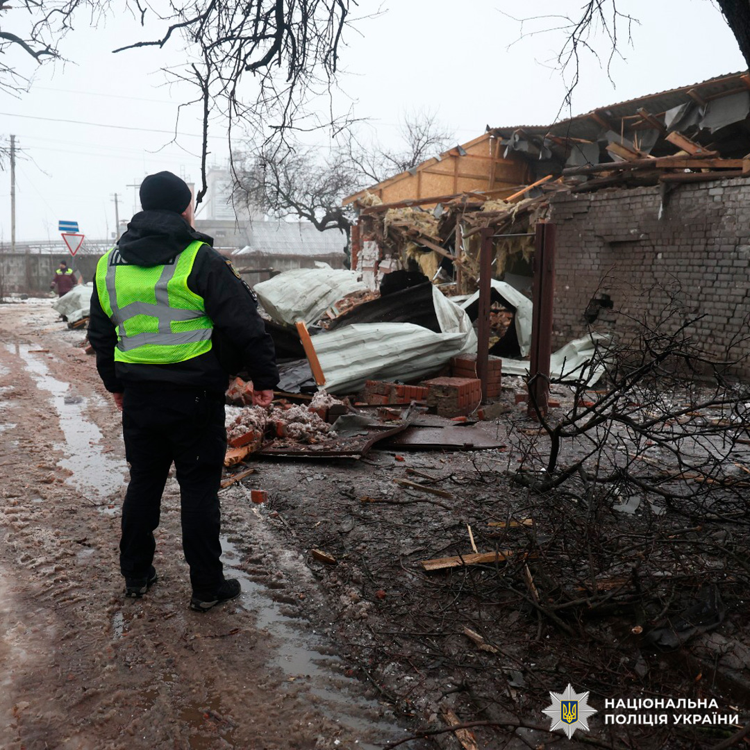 Зруйнована будівля після вибуху. На місці події працює представник Національної поліції України у світловідбивному жилеті.