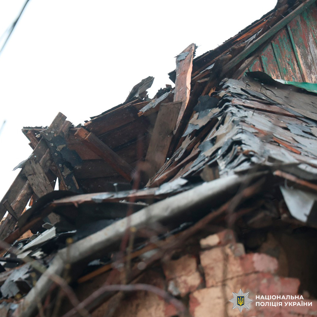 Зруйнований дах будівлі з пошкодженими балками та тріщинами у стіні.