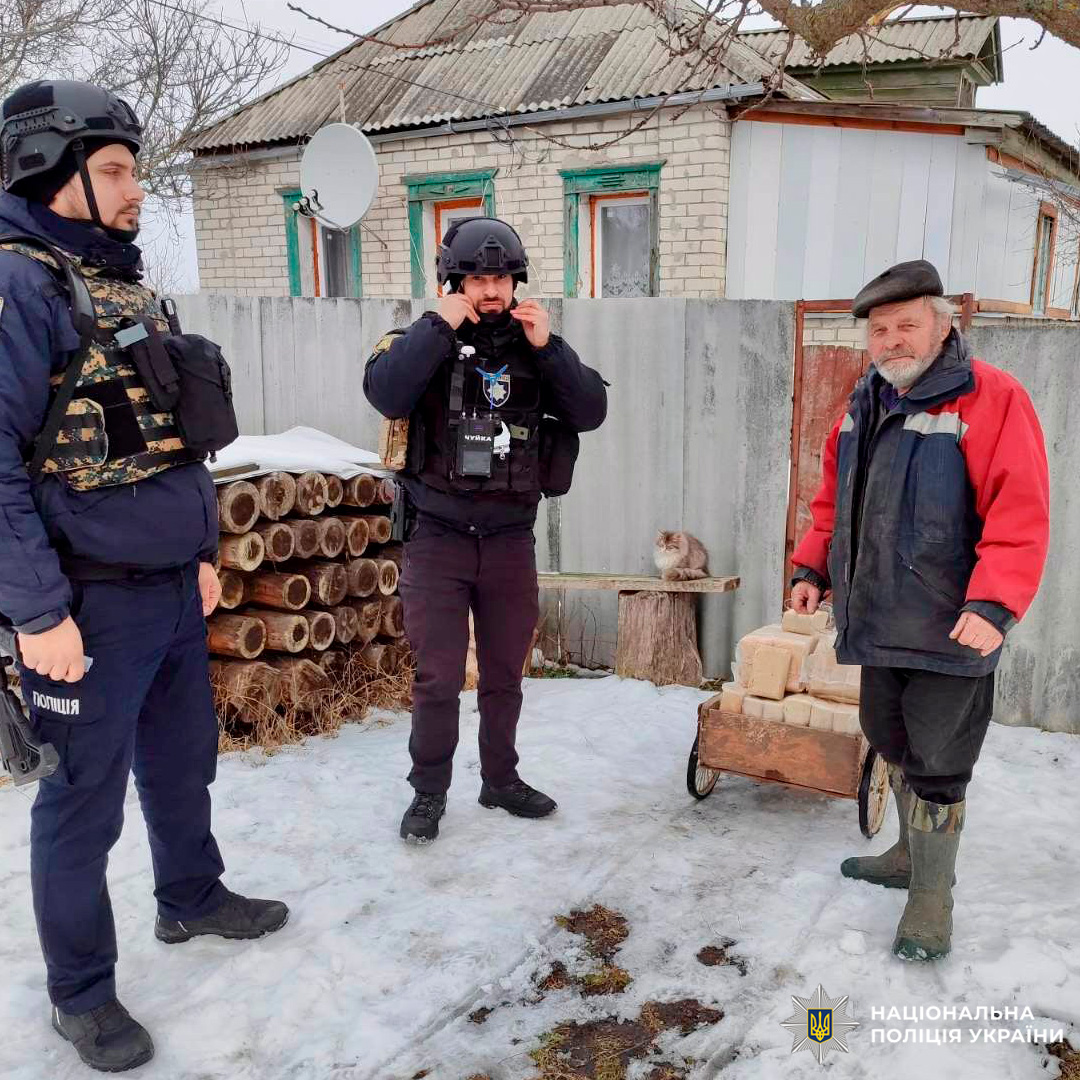 Поліцейські спілкуються з мешканцем громади, надаючи підтримку та інформацію в умовах холодної погоди.