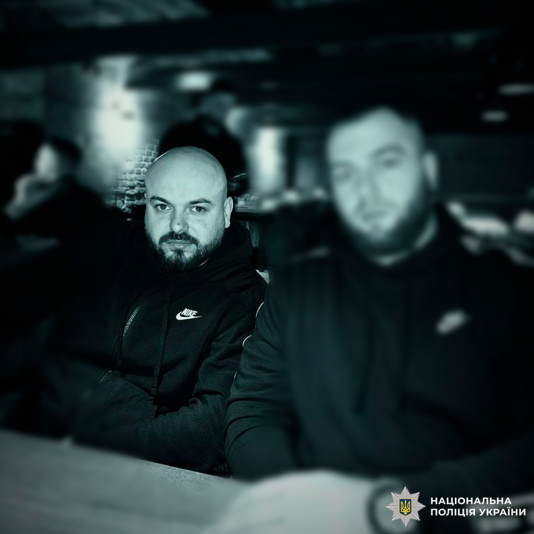 Двоє людей у темних худі, один чітко видно, інший розмитий.