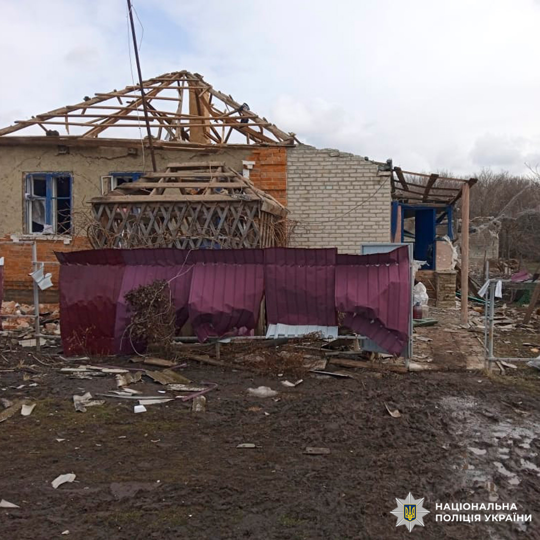 Зруйнована житлова будівля після вибуху: обвалений дах, пошкоджені стіни, уламки та зігнутий металевий паркан.