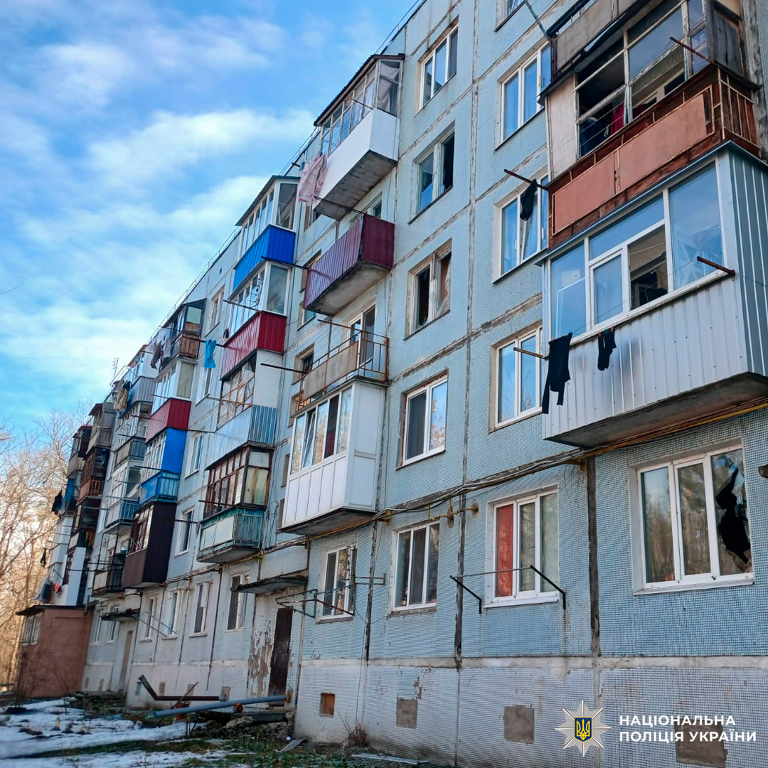 Багатоповерховий житловий будинок із пошкодженими балконами та вибитими вікнами, на фасаді сліди зношення та руйнувань.