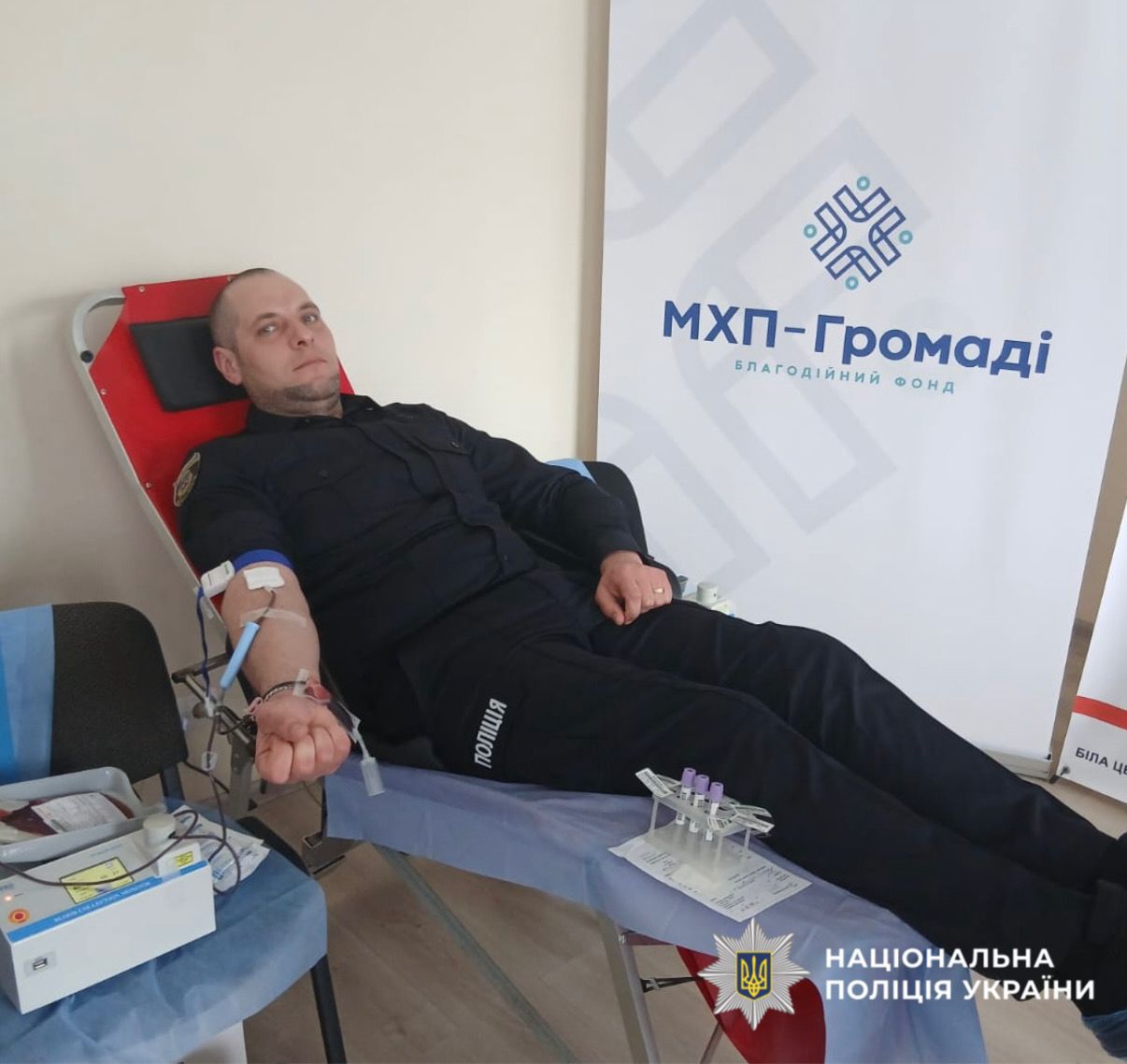 На фото зображено як поліцейські здають кров.