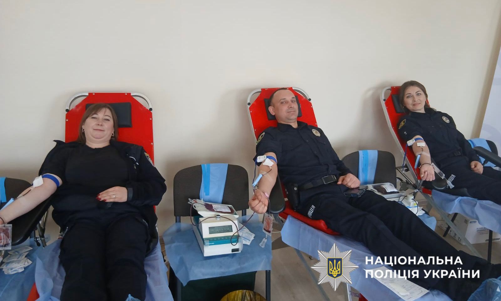 На фото зображено як поліцейські здають кров.