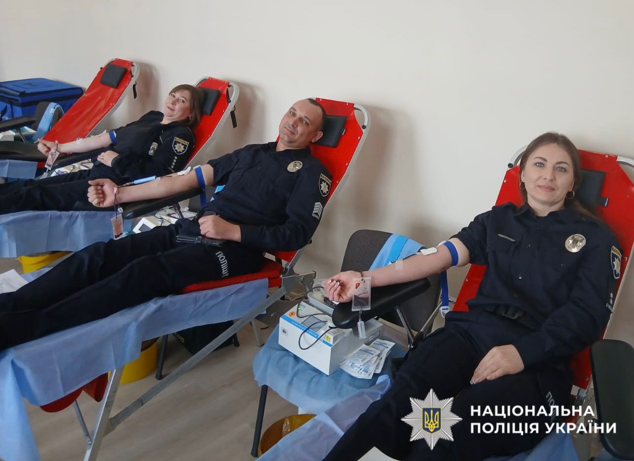 На фото зображено як поліцейські здають кров.