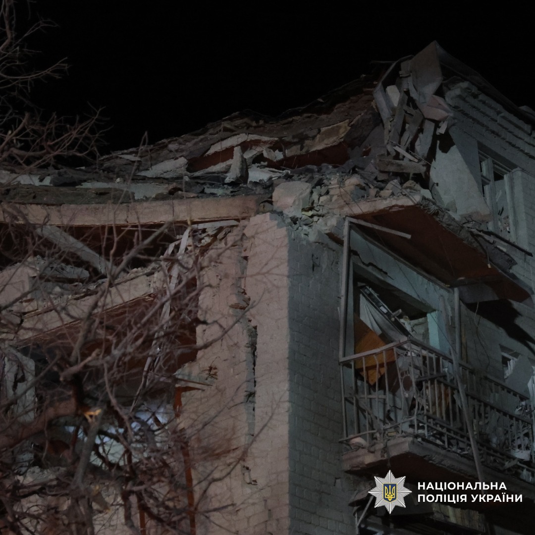 Зруйнована будівля: верхні поверхи обвалені, уламки розкидані навколо.