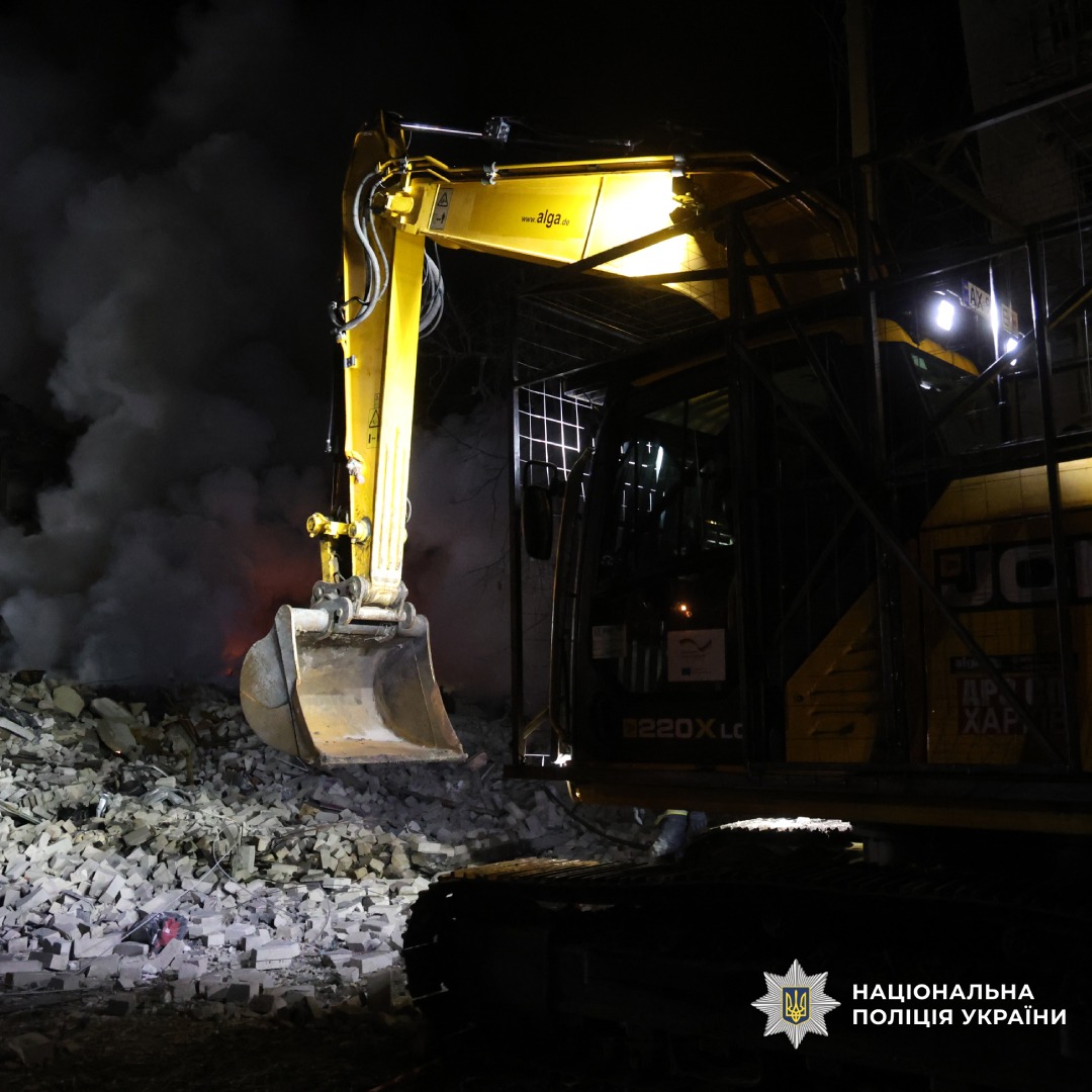 Екскаватор JCB працює серед уламків під час ліквідації наслідків руйнувань.