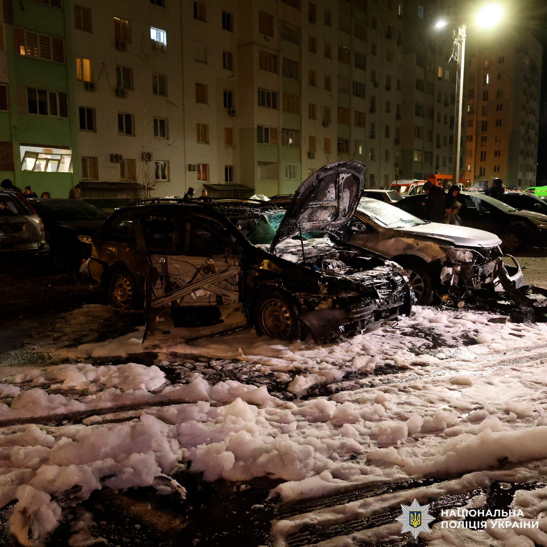 Знищені вогнем транспортні засоби, піна після гасіння, присутність правоохоронців.