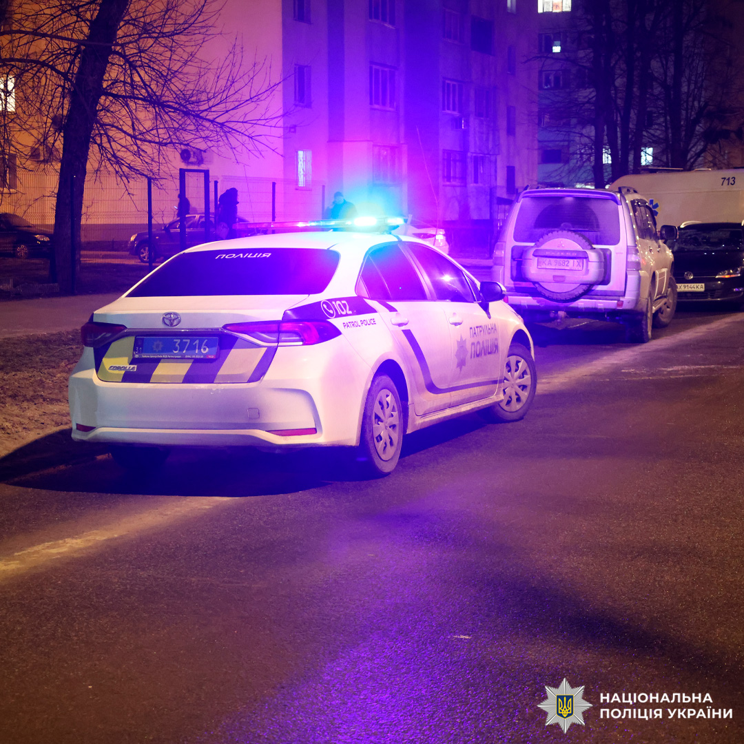 Службовий автомобіль патрульної поліції України з увімкненими проблисковими маячками під час нічного чергування.