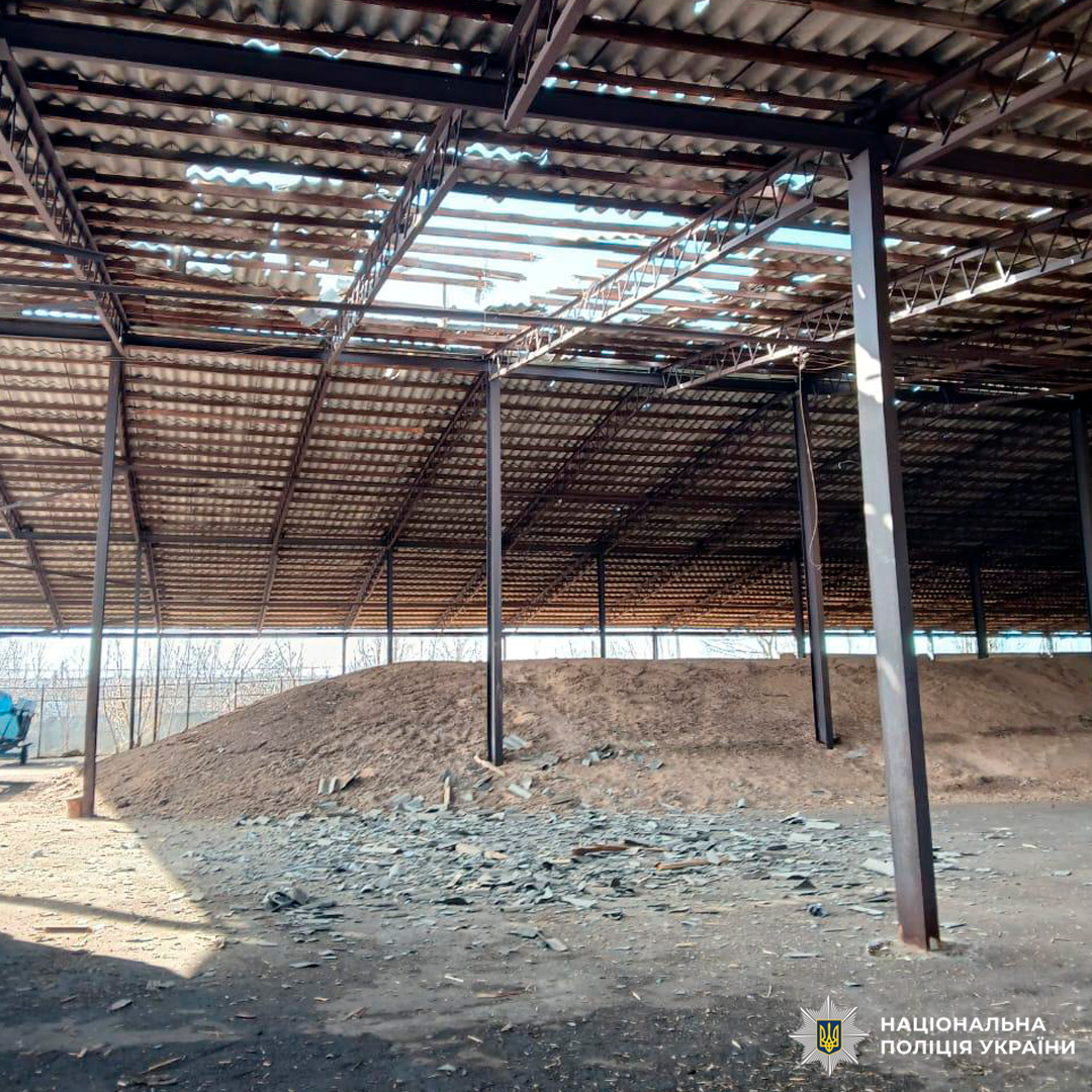 Зруйнована покрівля металевої споруди, уламки даху та насип ґрунту під час огляду поліцією