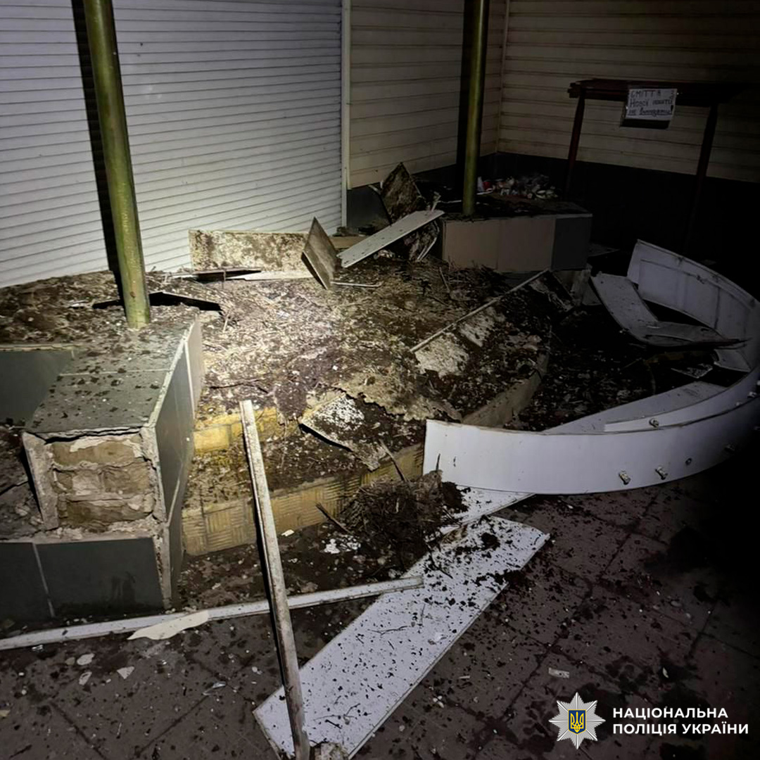 Зруйнована ділянка біля будівлі, уламки бетону та металу після вибуху.