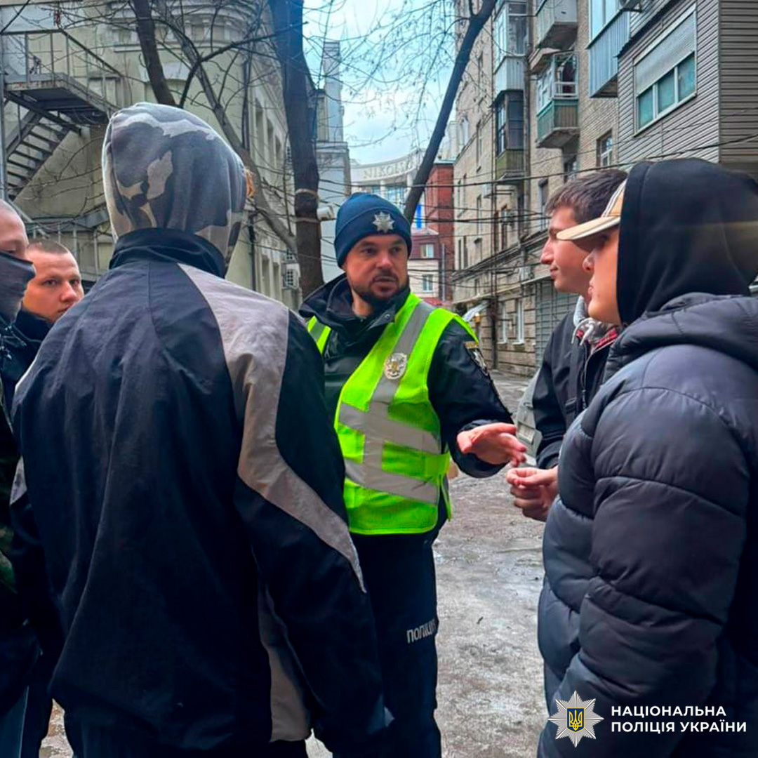 Поліцейські у формі та світловідбивних жилетах проводять інструктаж для громадян.