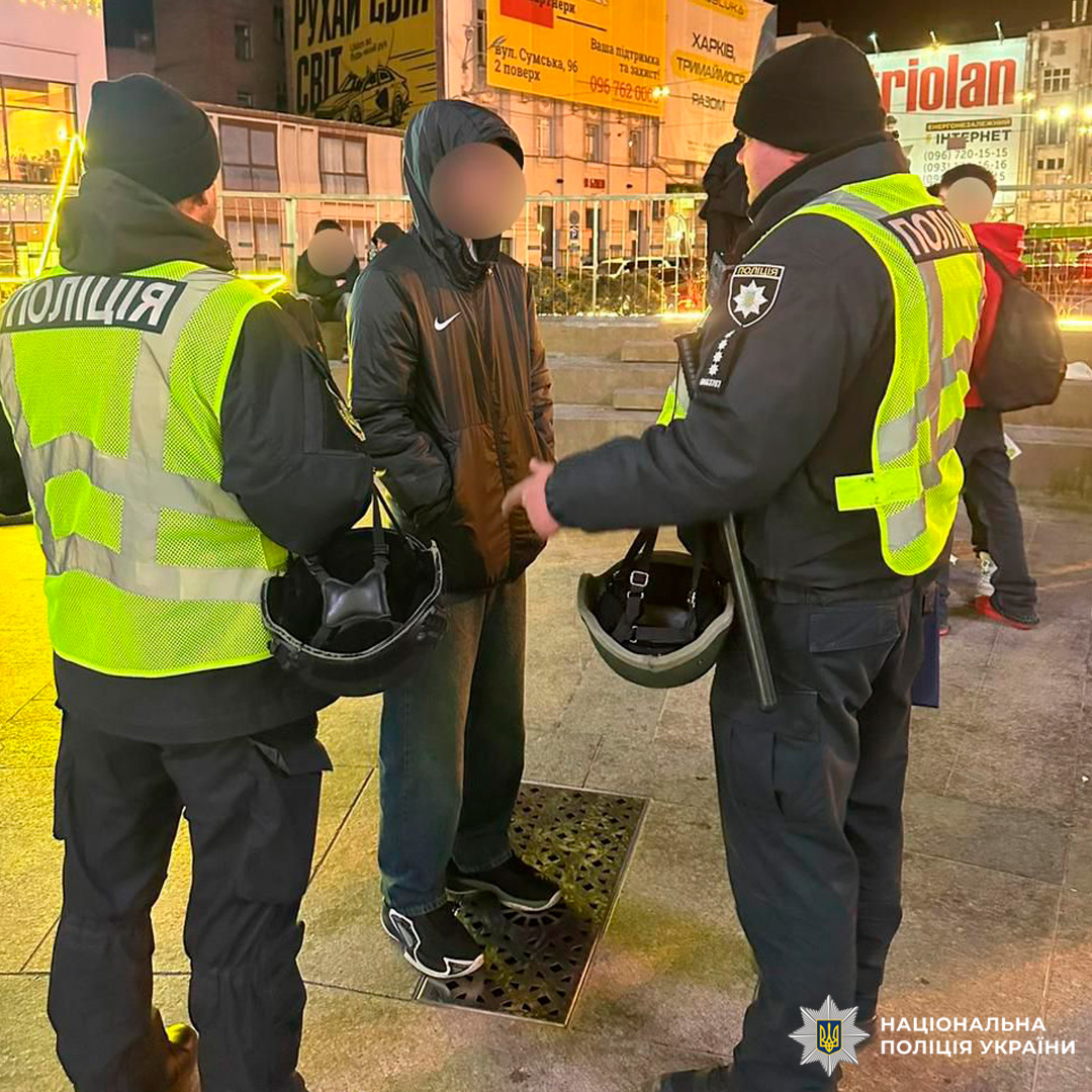 Поліцейські у формі та світловідбивних жилетах проводять інструктаж для громадян.