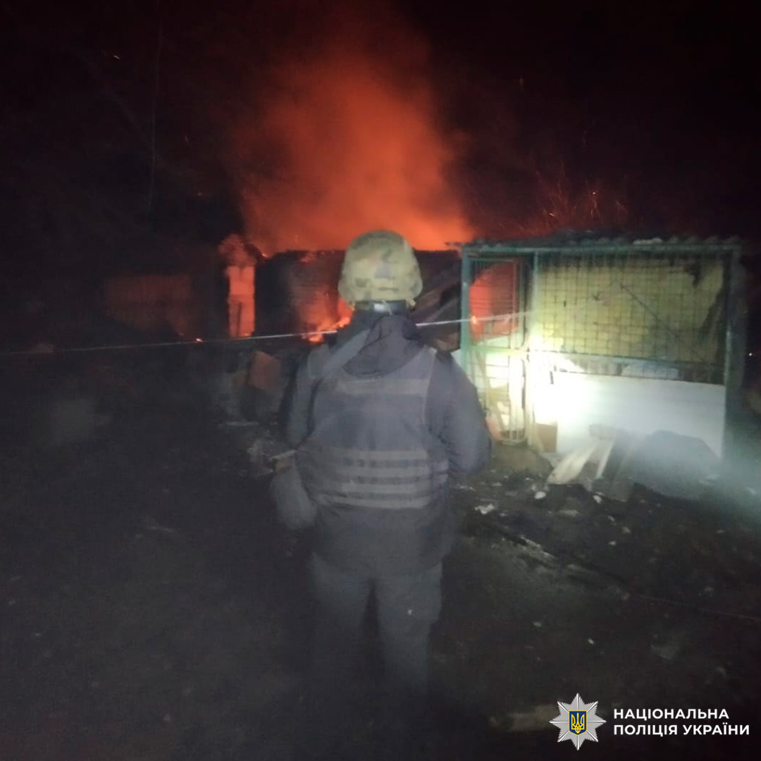 Нічна сцена: поліцейський фіксує наслідки пожежі та руйнування споруди.