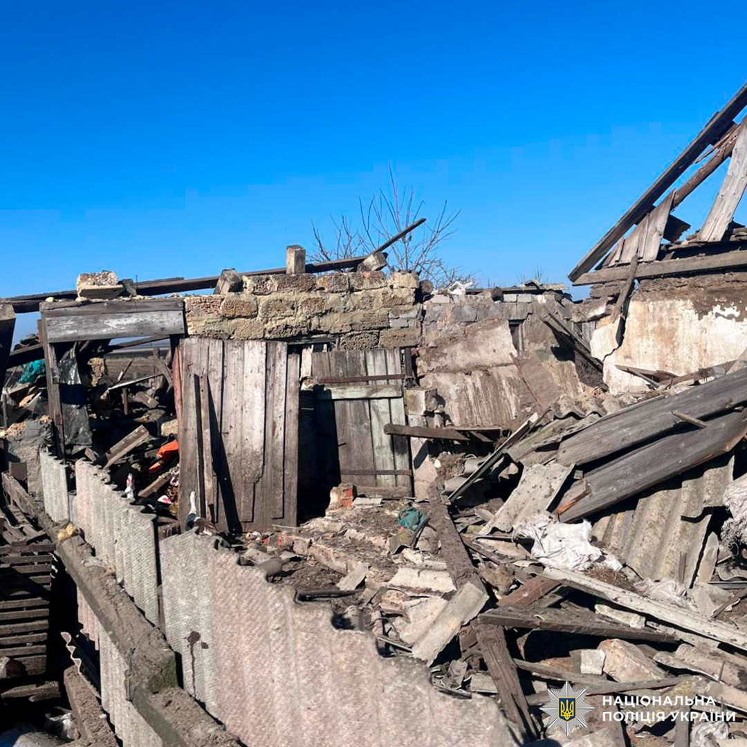 Зруйнована будівля з обваленими стінами та дахом, довкола розкидані уламки дерева, металу й цегли.