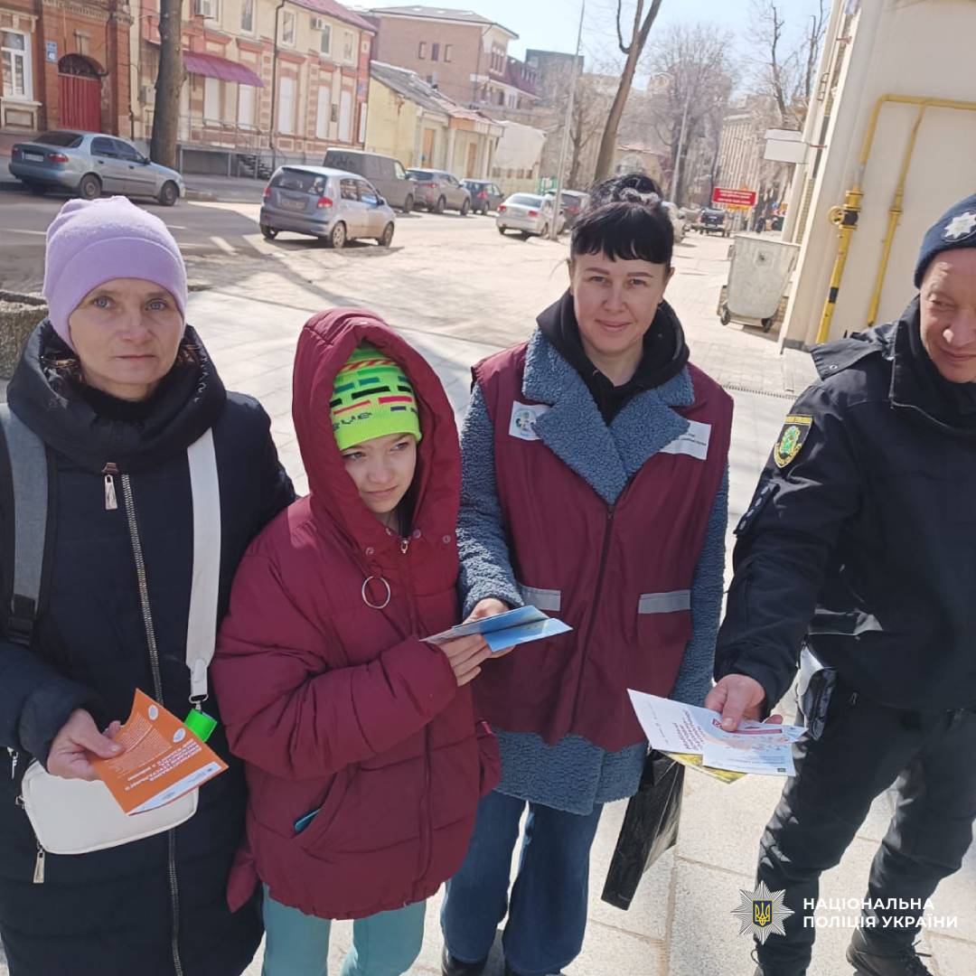 На цьому фото зображено офіцера Національної поліції України, який проводить інформаційно-роз'яснювальну роботу з громадянами на вулиці.