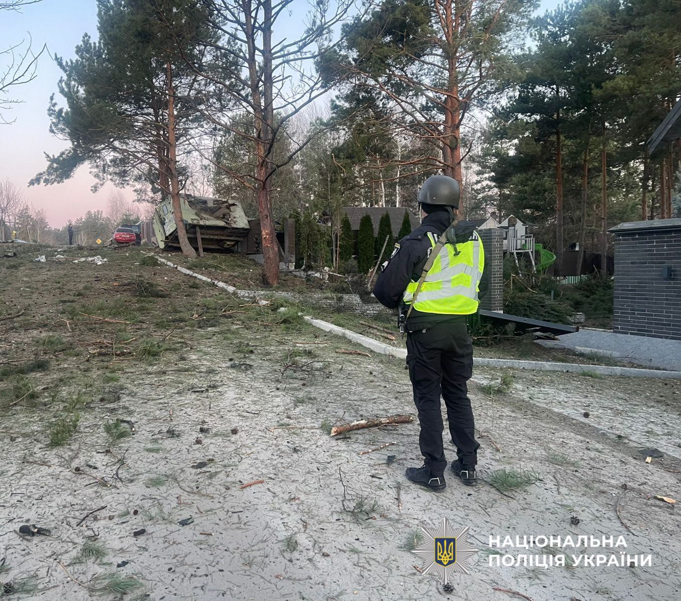 На фото зображений поліцейський, який проводить огляд місця події