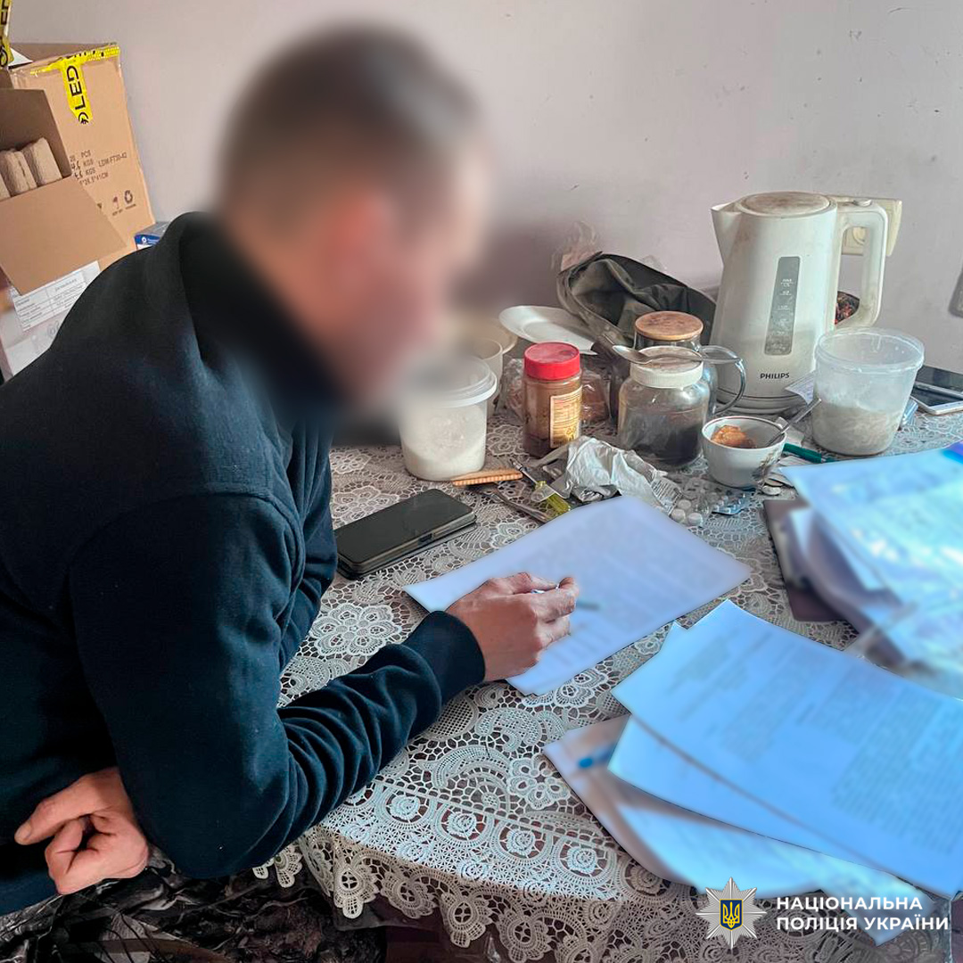 Людина знайомится з документами за столом із побутовими речами.