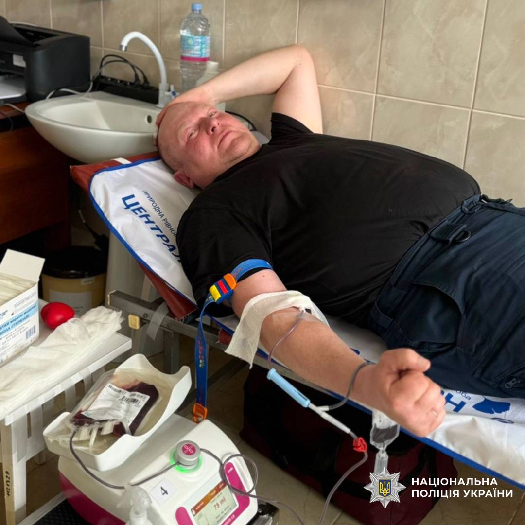 На фото зображений працівник поліції під час процедури здачі крові (донації)