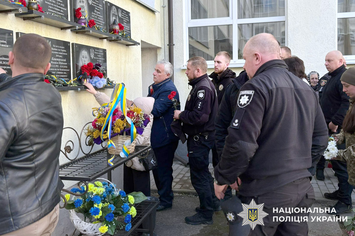 Поліцейські кладуть квіти до меморіальної дошки
