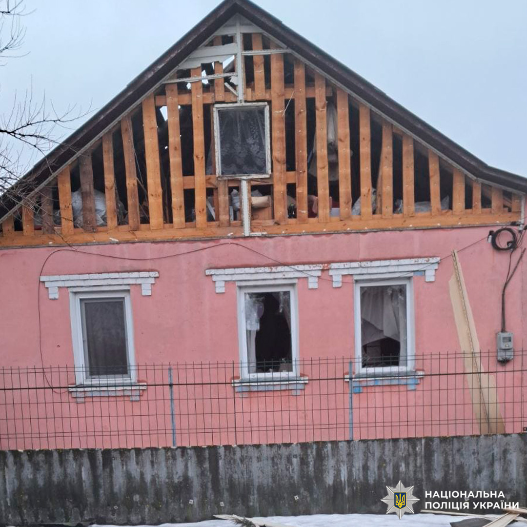 Житловий будинок із рожевим фасадом, пошкоджений ударом: оголені конструкції та розбиті вікна.