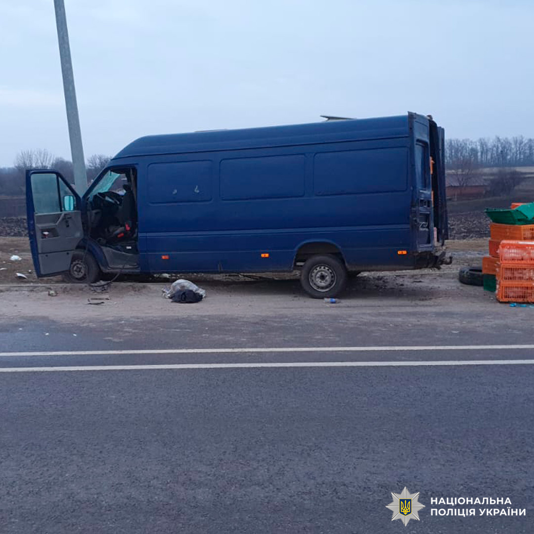 Фургон із пошкодженим колесом та відкритими дверима після аварії, поруч уламки та речі.