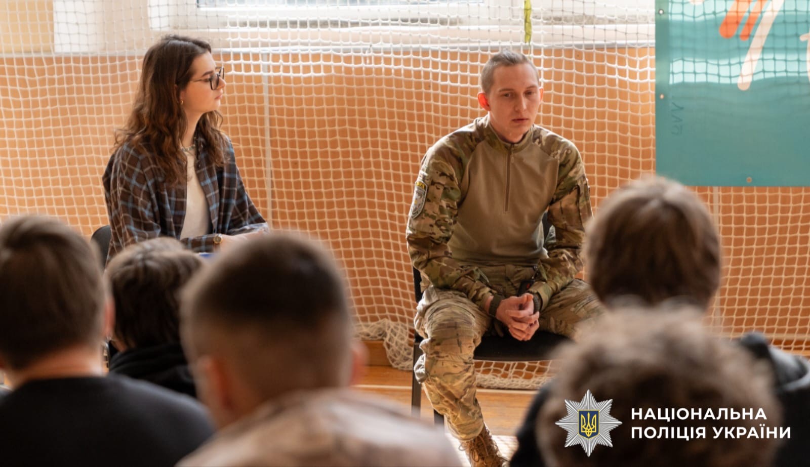 На фото зображений боєць, який розповідає дітям свою історію життя