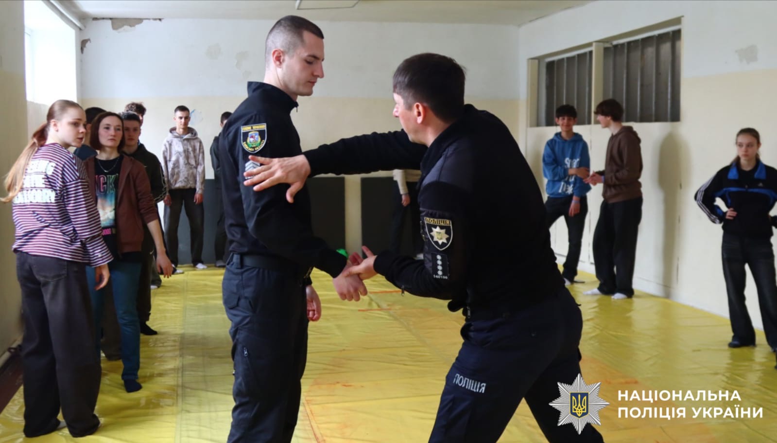 На фото зображений поліцейський та учень, які відпрацьовують вправи