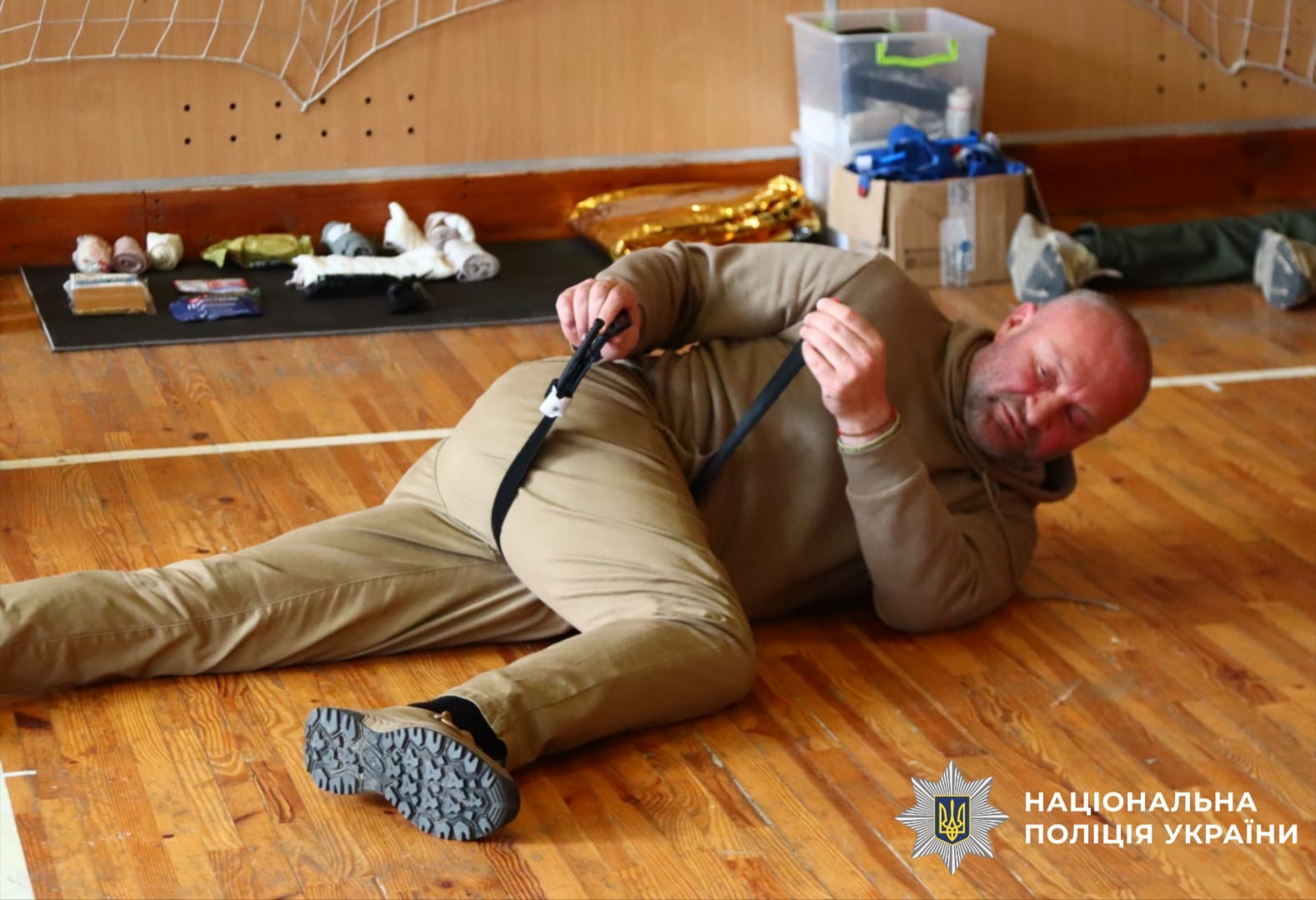 На фото зображений боєць, який показує як надавати до медичну допомогу