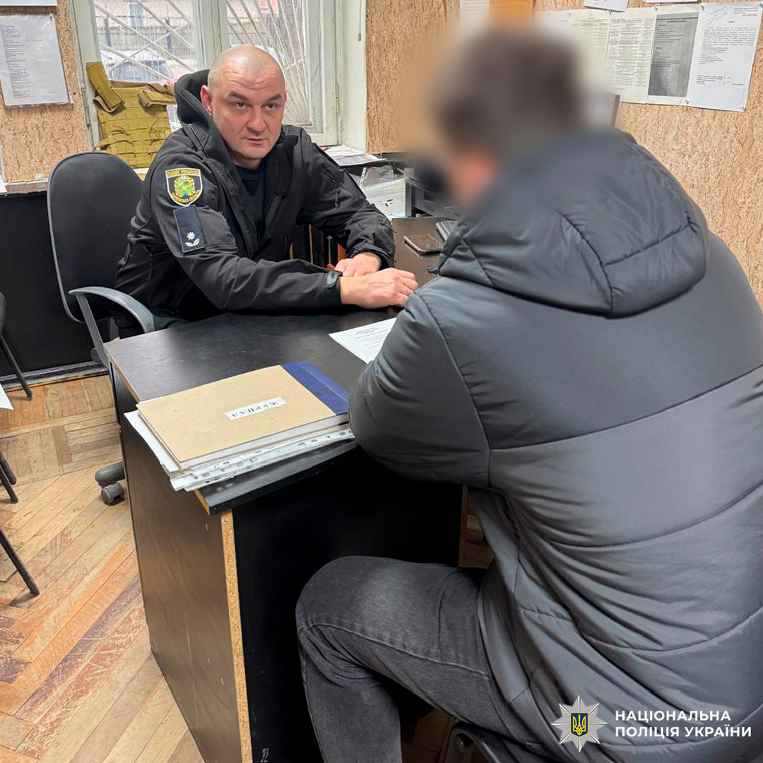 Поліцейський у формі розмовляє з чоловіком у цивільному одязі в робочому кабінеті.