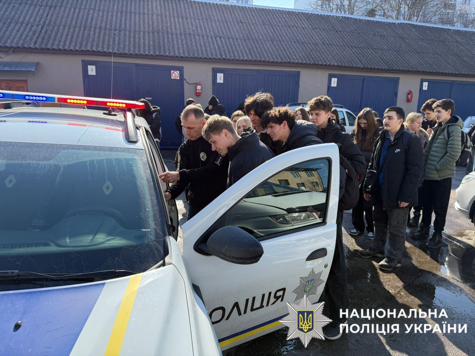 На фото поліцейські демонструють службовий автомобіль відвідувачам.
