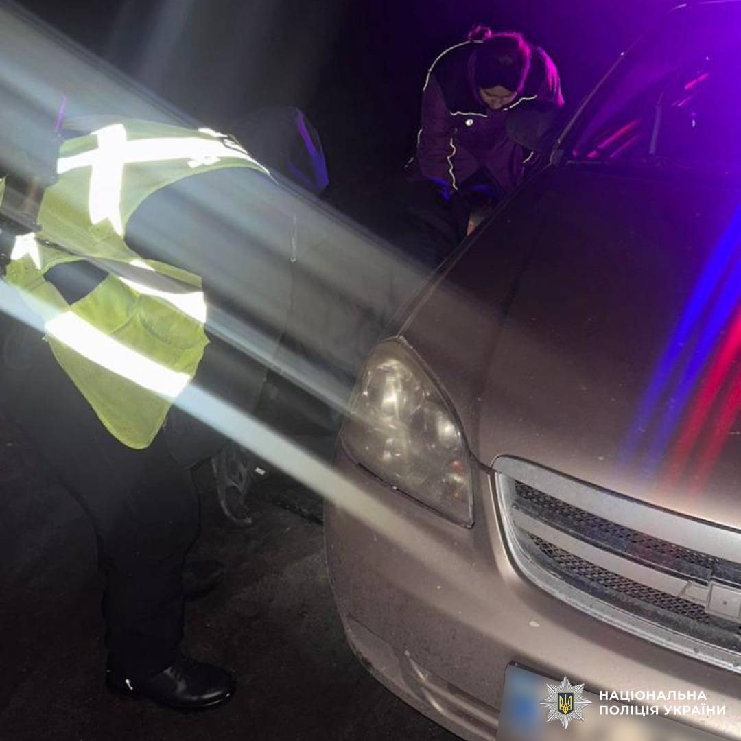 На фото поліцейські Харківщини які допомогли водію усунути несправність автомобіля під час патрулювання