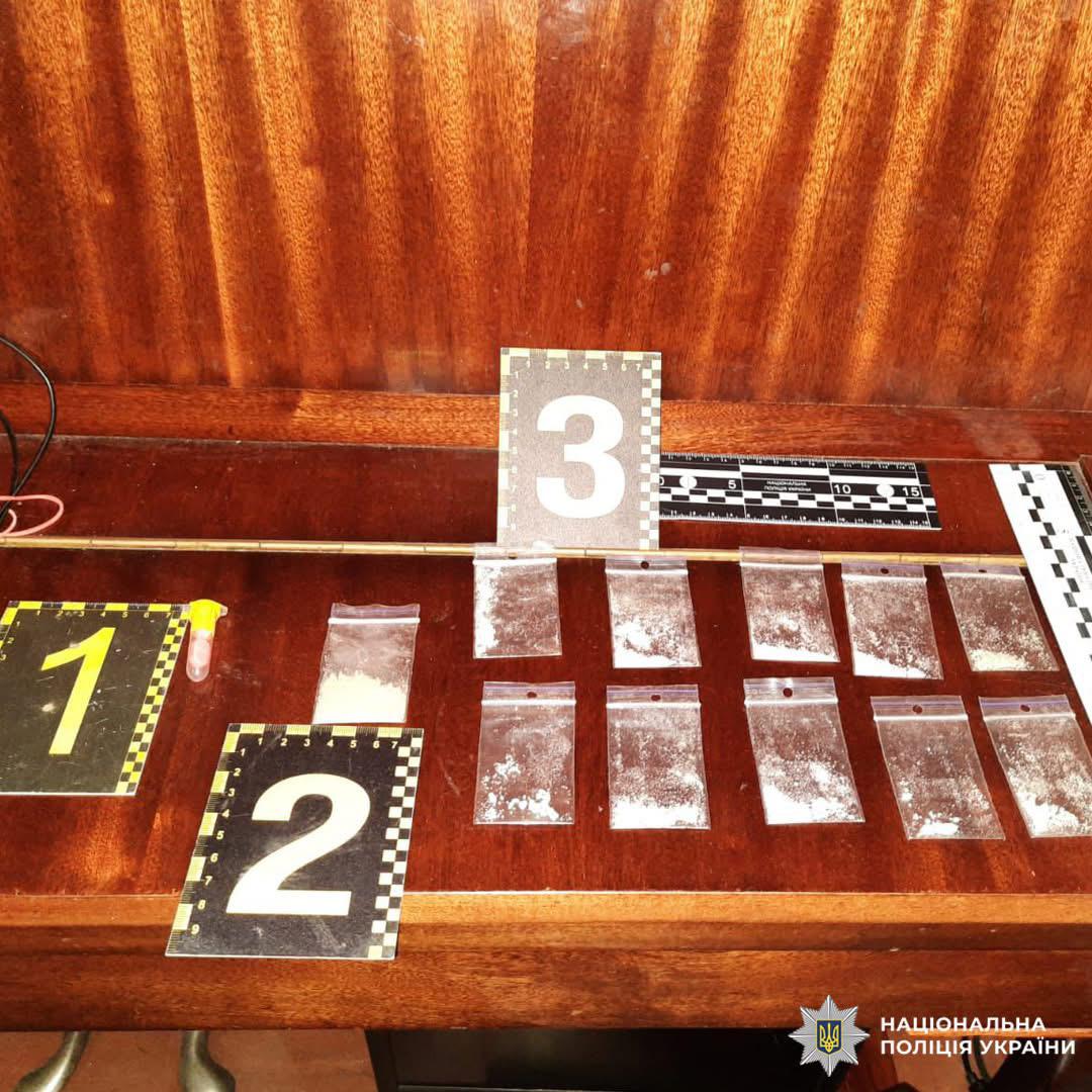 Пакети з порошком та флакон, позначені маркерами 1–3. Використано масштабну лінійку для вимірювання.